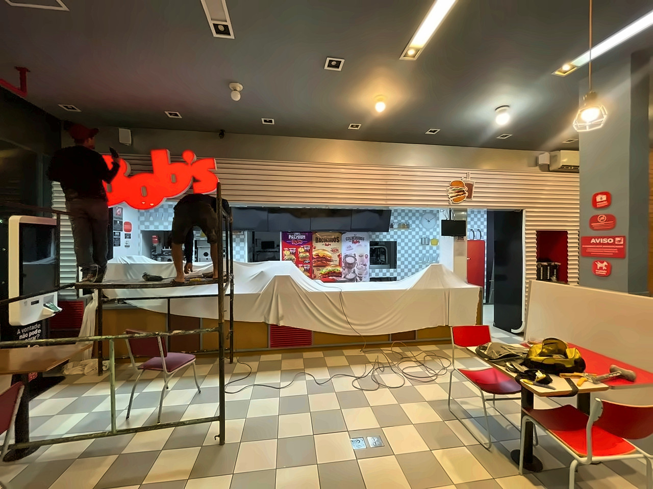 Equipe da Enobras em andaime montando o letreiro de uma unidade Bob's